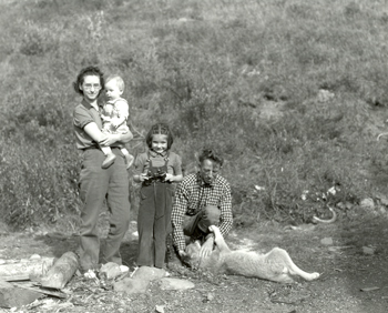 The Murie family stand for a family picture by the shore of a river