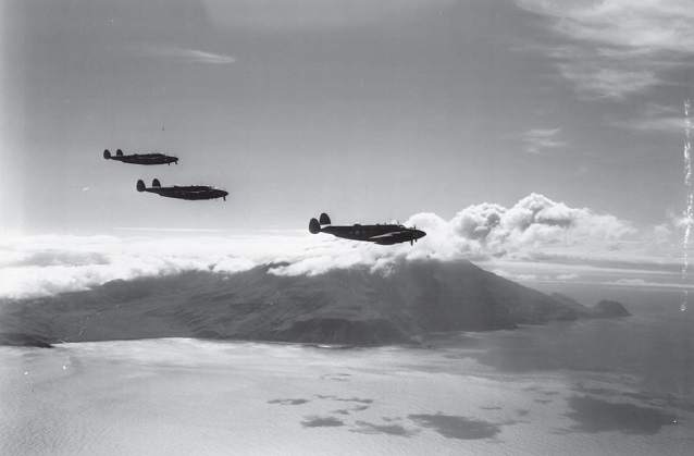 Three airplanes fly above clouds with volcano and sea in distance. Three airplanes fly above clouds with volcano and sea in distance.