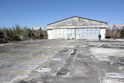 A set of tracks built into a concrete pad leads to a double-doored garage building.