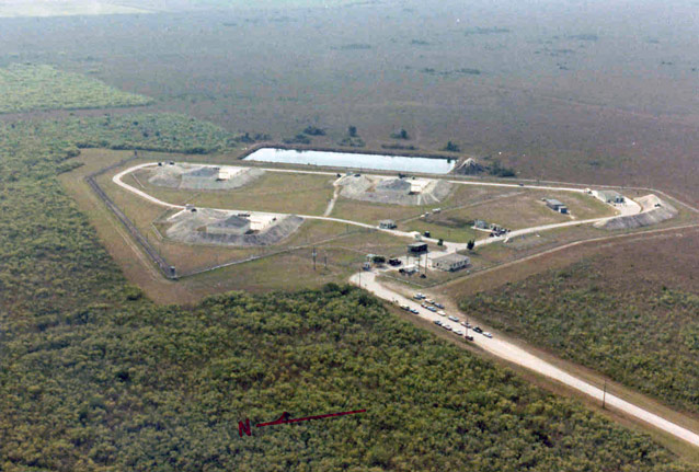 Aerial view of the launch area shows roads and structures surrounded by a green landscape.
