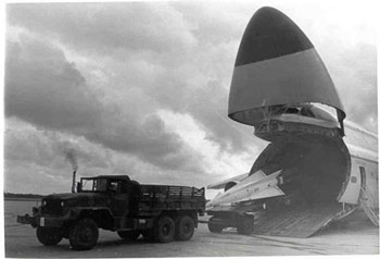 An army truck unloads a missile from an air carrier. An army truck unloads a missile from an air carrier.
