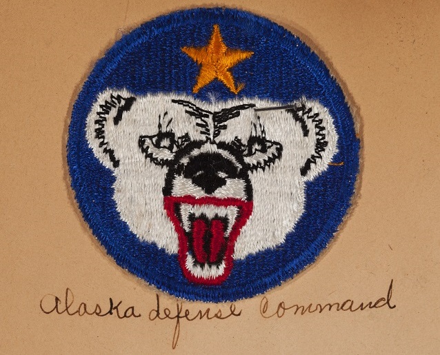 Blue patch with white bear head.  Writing beneath reads "Alaska Defense Command"