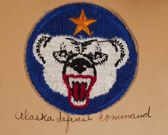 Blue patch with white bear head. Writing beneath reads "Alaska Defense Command" Blue patch with white bear head. Writing beneath reads "Alaska Defense Command"
