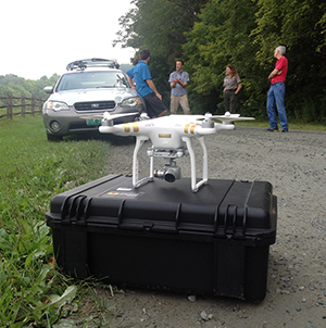 Close-up view of a quadcopter unmanned aircraft and three people. Close-up view of a quadcopter unmanned aircraft and three people.