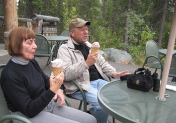 Two adults enjoy an ice cream cone. Two adults enjoy an ice cream cone.