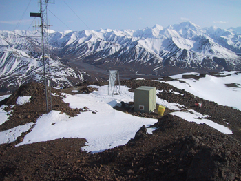 Seismic station in Denali with antenna, solar panel, and equipment hut.