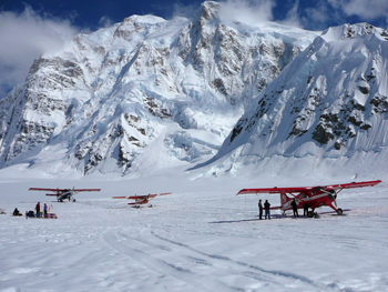 Three small planes on a beautiful glacier.