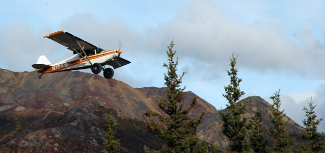 a small plane flies over mountains