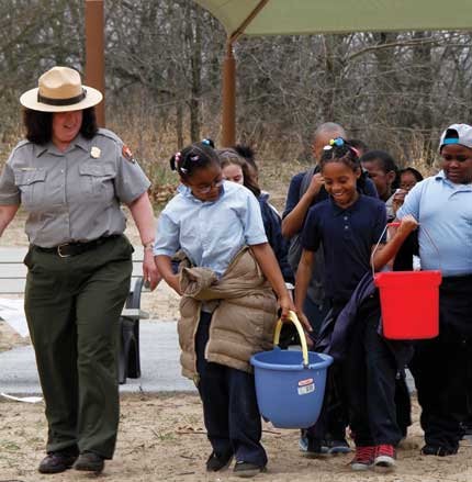 A park ranger leads a group pf schoolchildren in the Nature Play Zone 