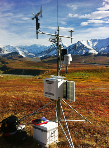 a climate station stands amidst fall-colored tundra