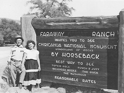Two visitors pose by a sign for Faraway Ranch advertising trips by horseback to Chiricahua NM Two visitors pose by a sign for Faraway Ranch advertising trips by horseback to Chiricahua NM