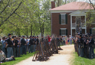 people dressed in civil war era clothing in front of a small building