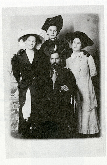 historic photo of a group of three standing women and a seated man