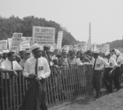 marchers with signs stand on far side of fence, B&W photo marchers with signs stand on far side of fence, B&W photo