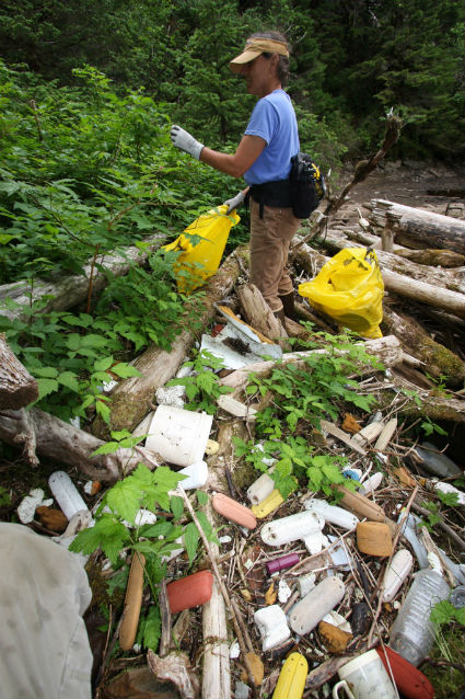 woman standing in marine debris pile in Kenai Fjords National Park