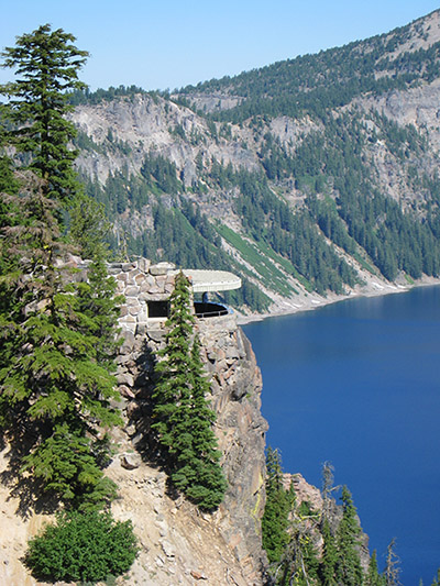 The Sinnott Memorial blends into the stones of an observation point, overlooking a blue lake. 