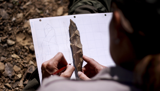 a person sketches an archaeological artifact