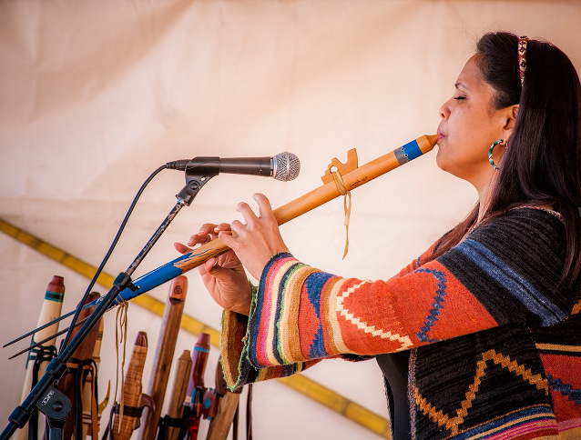 An American Indian woman plays the flute at the American Indian Arts Festival An American Indian woman plays the flute at the American Indian Arts Festival