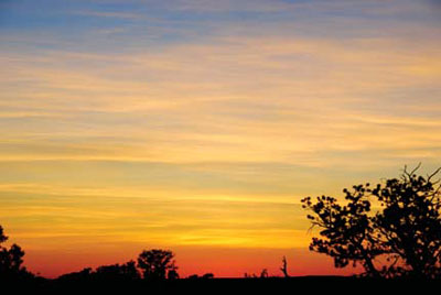 Clouds and sky turning orange and red over Navajo National Monument at sunset