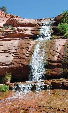 Water cascades down red rock faces at Navajo National Monument Water cascades down red rock faces at Navajo National Monument