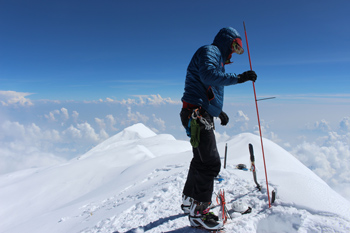 a mountaineer probes an ice cap