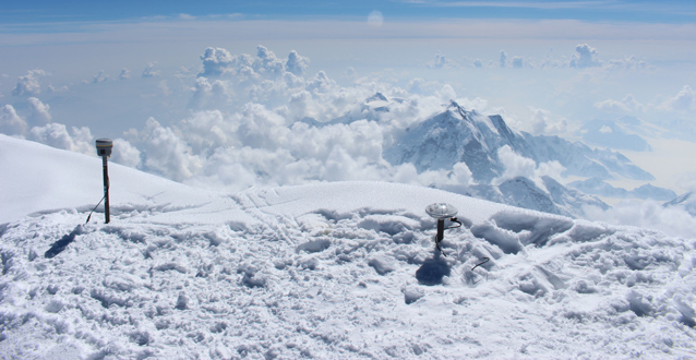 Two GPS antennas stick out of snow on a mountain