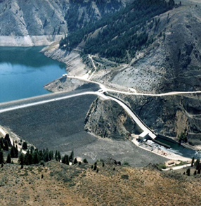 A picture of Anderson Ranch Dam surrounded by blue water and tall mountains 