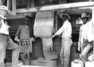 Black and white photo of people holding U.S.R.S labeled bags