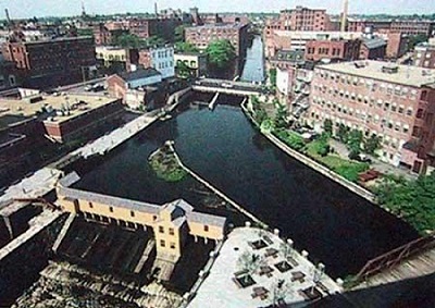 Photo of dark blue water flowing through a dam in a historic town