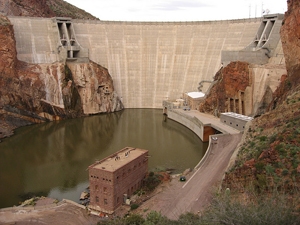 Photo of Theodore Roosevelt Dam with a few buildings near by 