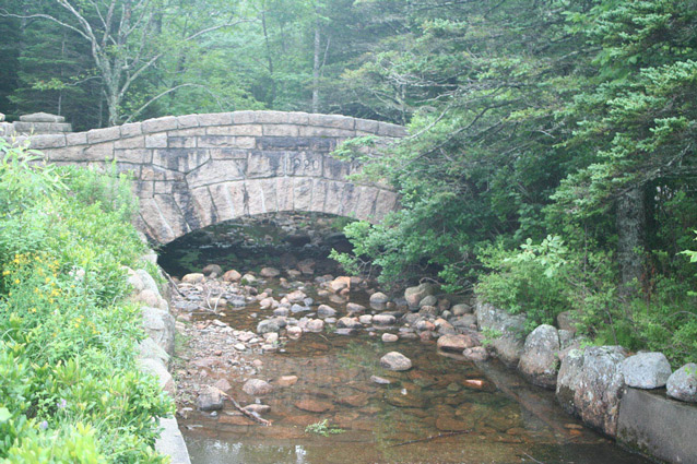 A stone bridge arches over a shallow, stone-lined stream. (OCLP, 2008) A stone bridge arches over a shallow, stone-lined stream. (OCLP, 2008)