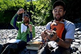 two men handling birds and taking various measurements