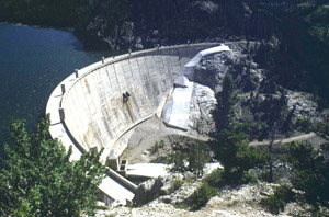 Photo of Gibson Dam's large crest shape with water in the background 