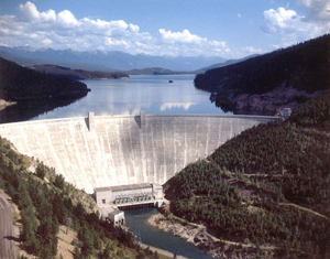 Sky view Hungry Horse Dam surrounded by mountains and clear water 