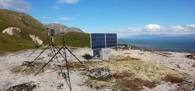 Microphones and a solar panel with mountains in the background