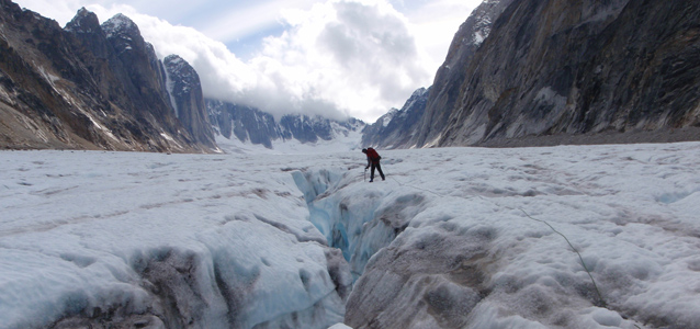 man standing on glacier in mountains