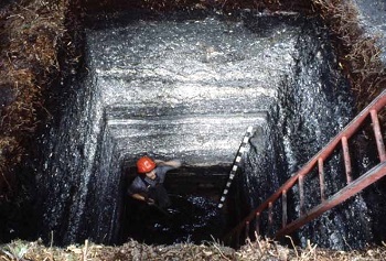 man in a deep square excavation site man in a deep square excavation site