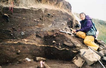 woman sitting by exposed ground layers