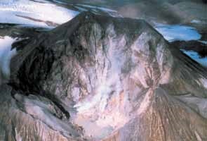 aerial view into a steaming summit crater