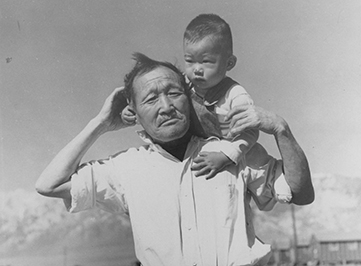 Male child sitting on the shoulder of his grandfather