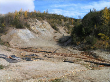 view of creek with gravel hill in background