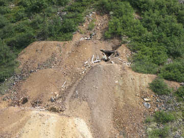 view of a wooden mine entrance in an eroding hillside