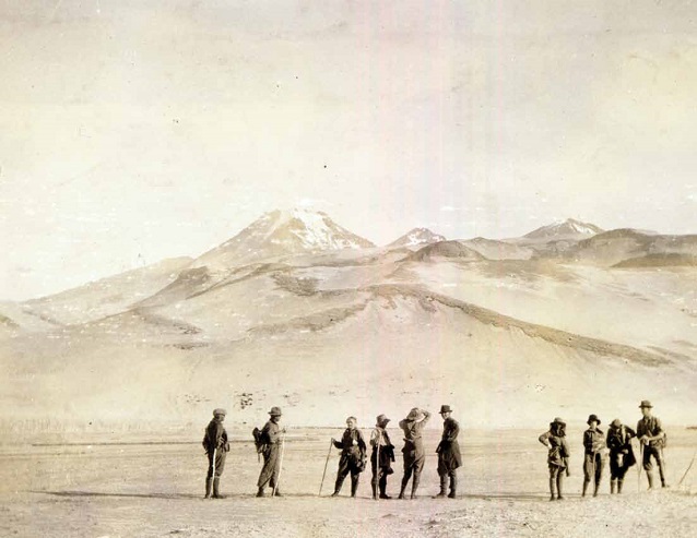 historic photo featuring a group of people with mountains in the distance historic photo featuring a group of people with mountains in the distance