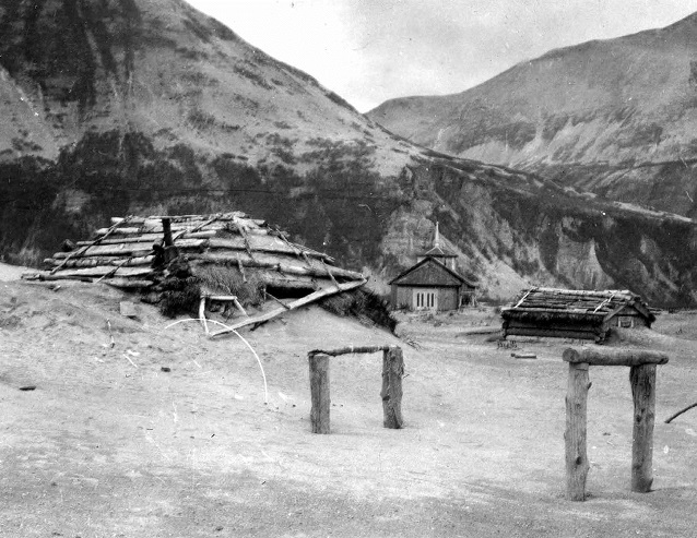 black and white photo of ash filling in around houses in a valley