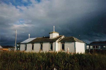 a white, one-story Russian Orthodox sits in the grass