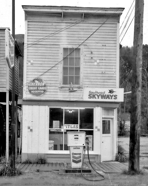 Black and white photo of a building and a gas pump. Black and white photo of a building and a gas pump.