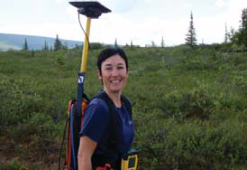 woman holding GPS unit in shrub vegetation woman holding GPS unit in shrub vegetation