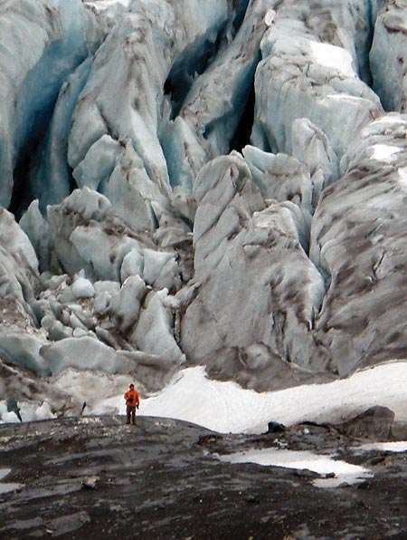 man dwarfed by a giant glacial moraine man dwarfed by a giant glacial moraine
