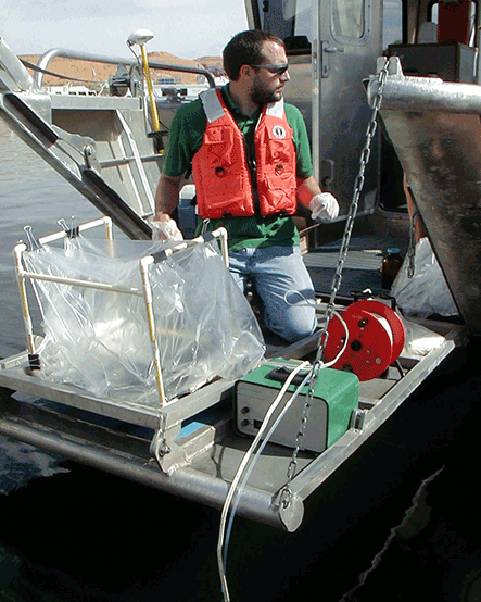 Man in a lifejacket on a boat with scientific equipment