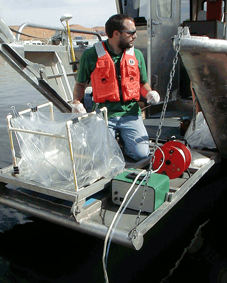 Man in a lifejacket on a boat with scientific equipment Man in a lifejacket on a boat with scientific equipment